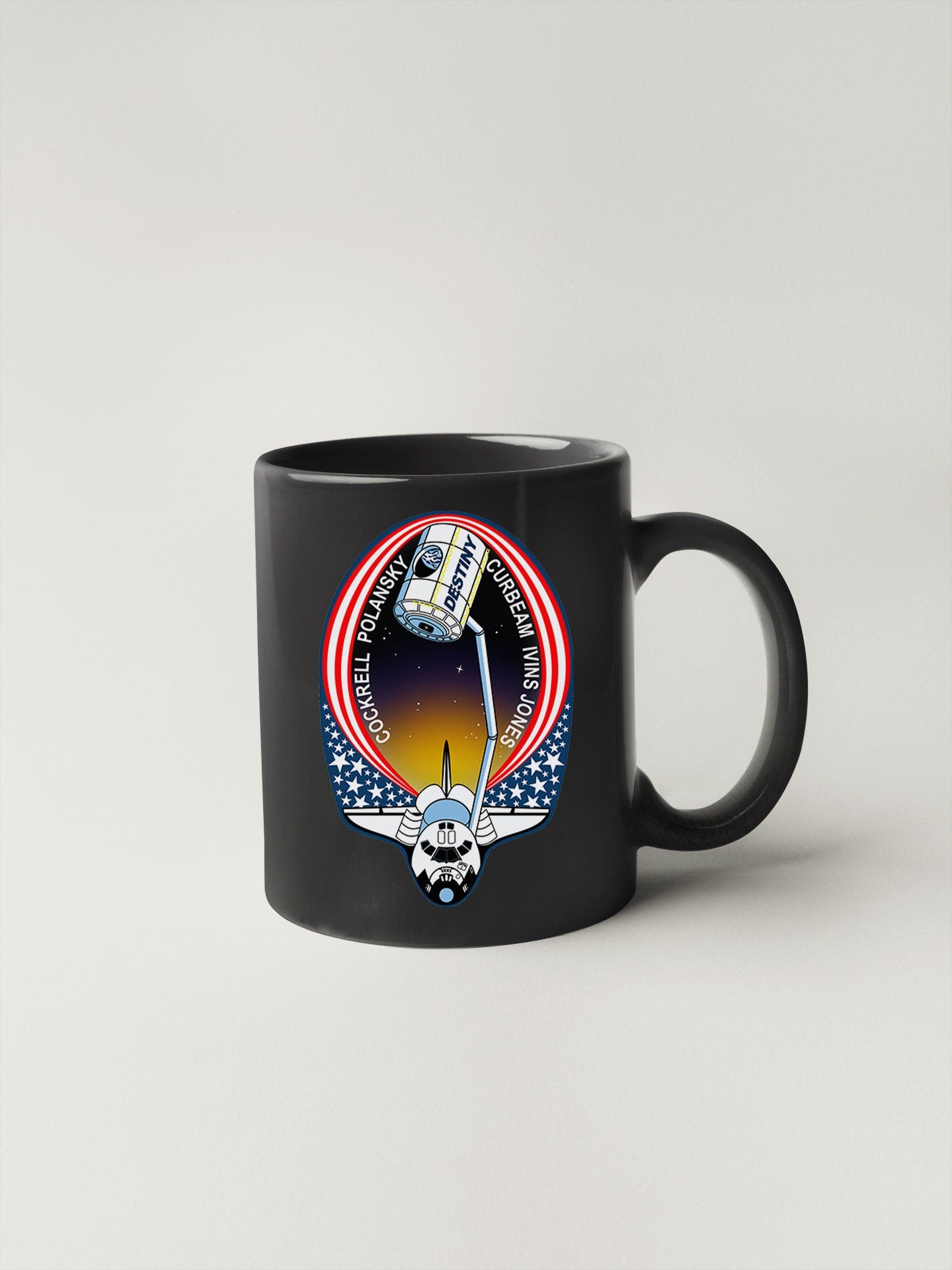 a black coffee mug with a space shuttle on it