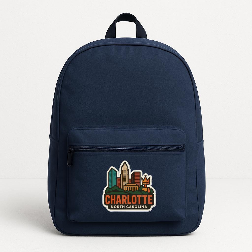 A navy blue backpack with a cityscape sticker on the front, featuring the text "CHARLOTTE NORTH CAROLINA".