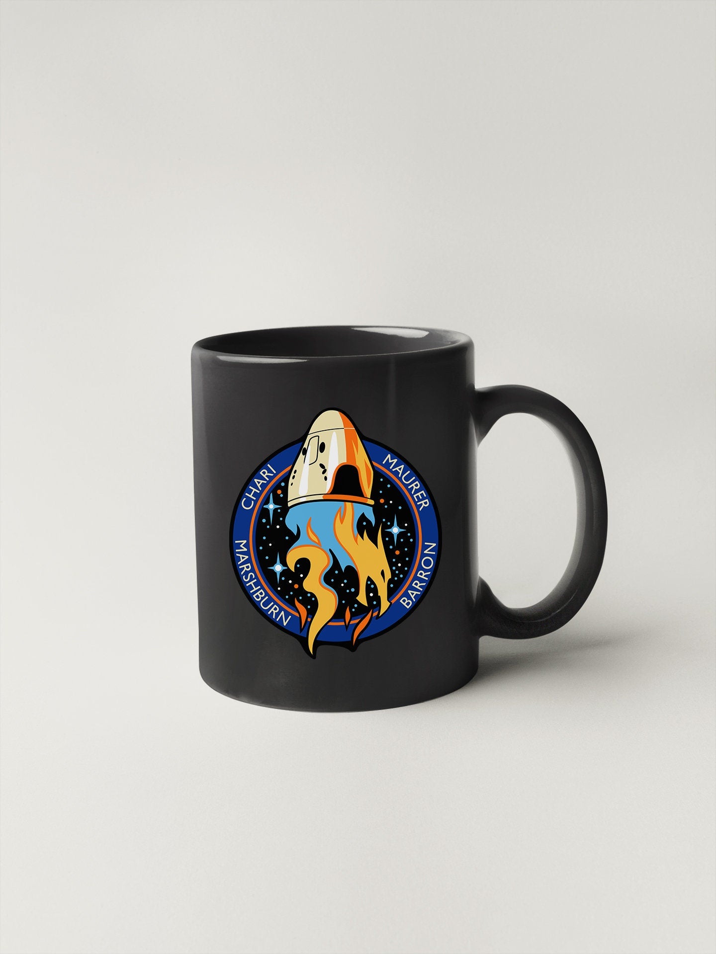 a black coffee mug with a space shuttle on it