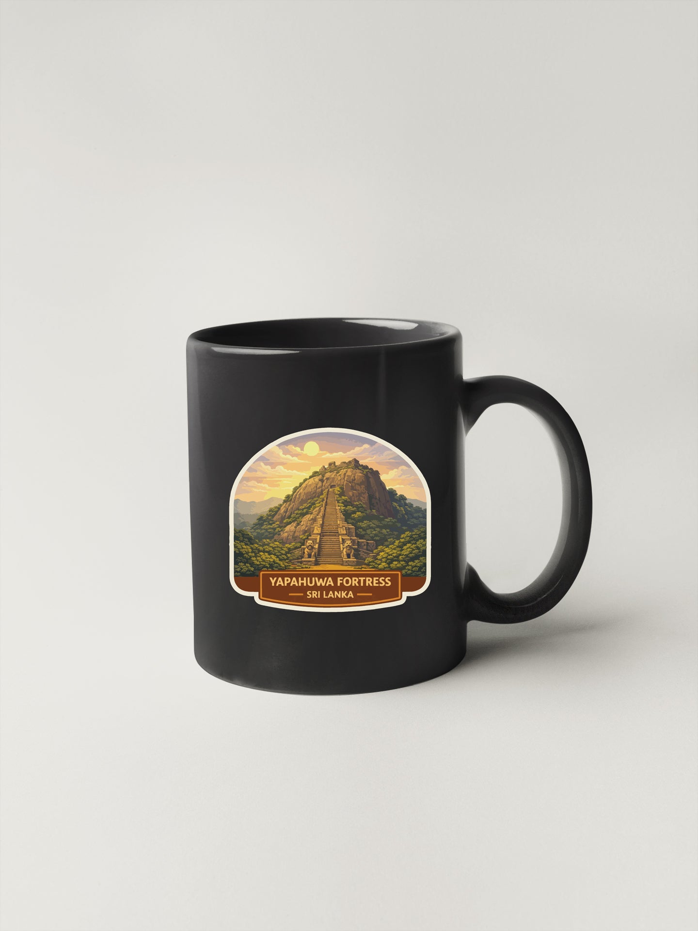 A black coffee mug with a label depicting the Yapahawa Fortress in Sri Lanka.