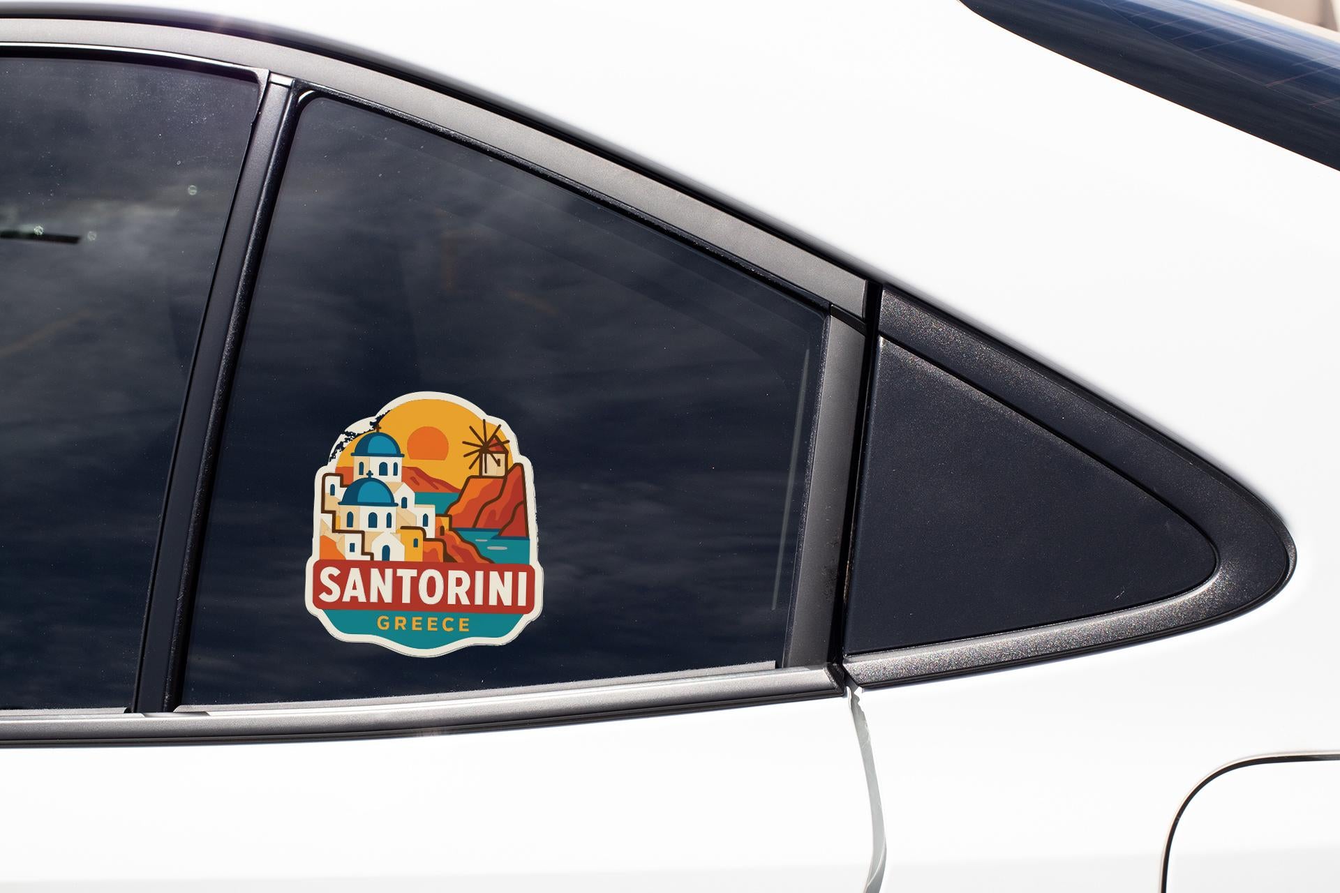 A sticker on the side of a car window, depicting a scenic view of Santorini, Greece.