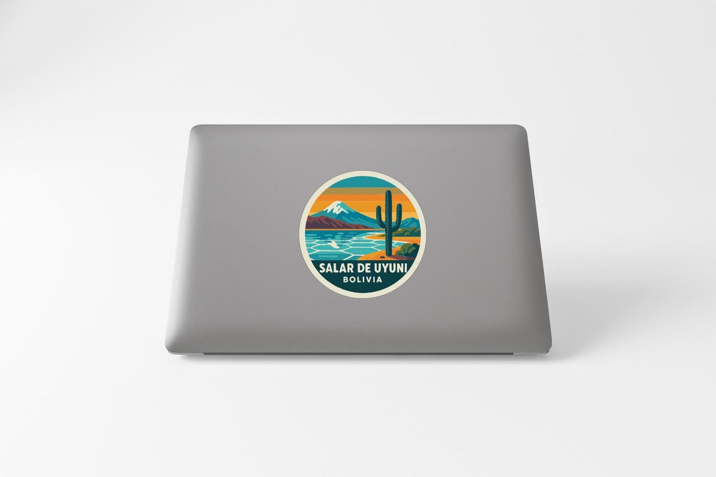 a sticker on the back of a laptop with a desert landscape and a cactus.