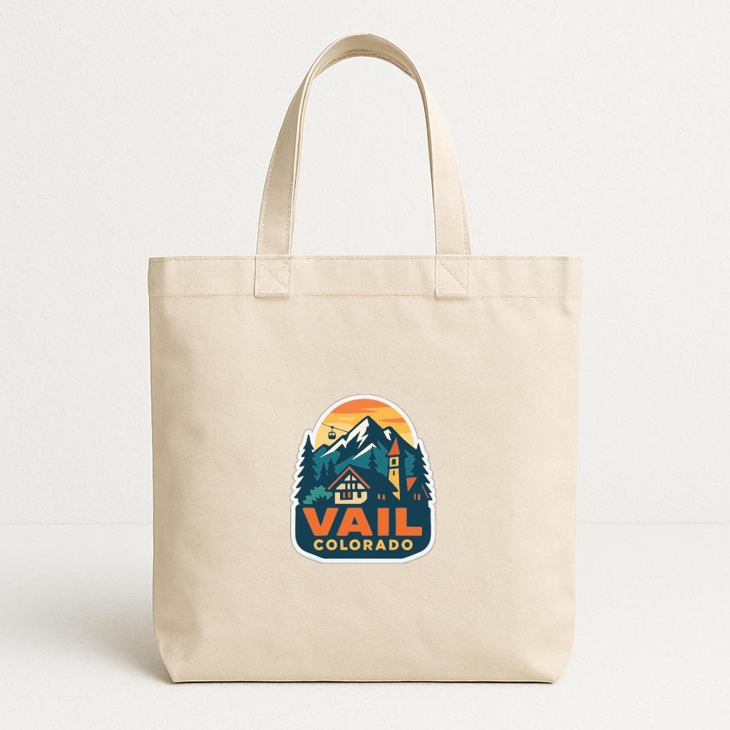 A beige tote bag with a graphic design featuring a mountain landscape and the text "Vail, Colorado" printed on it.