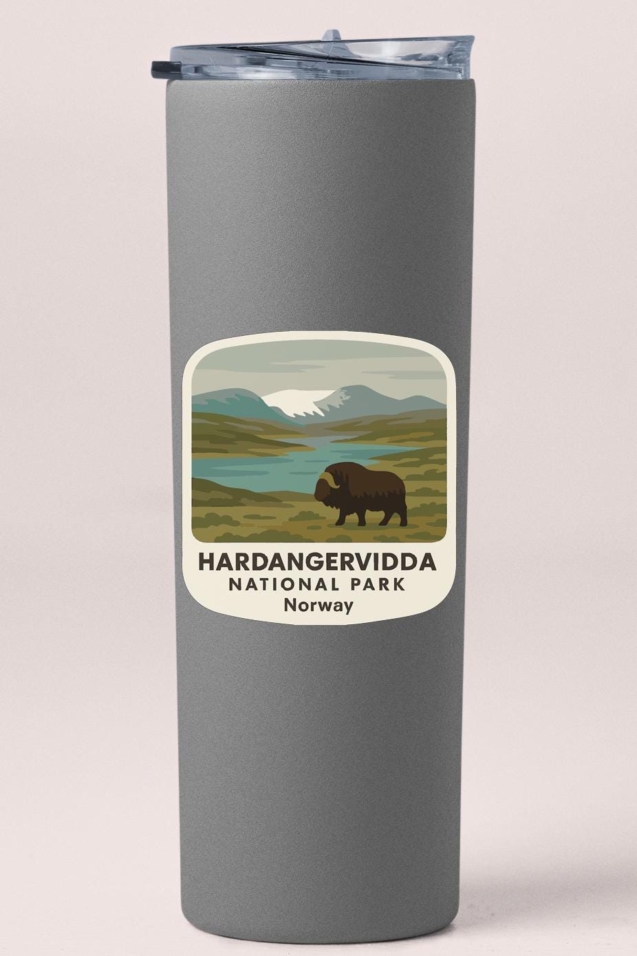 A gray tumbler with a label that features an illustration of a bison in a grassy field, with mountains in the background, and the text "HARDANGERVIDDA NATIONAL PARK NORWAY".