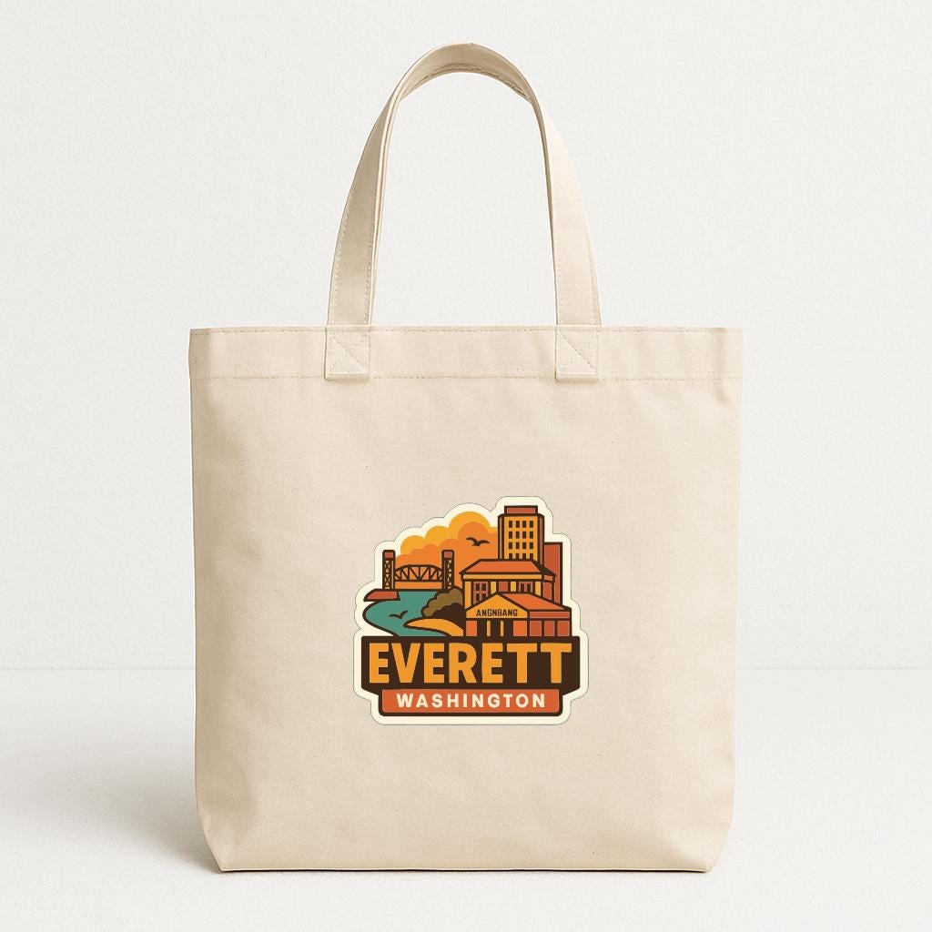 A beige tote bag with a printed design of Everett, Washington, featuring a cityscape and a bridge.