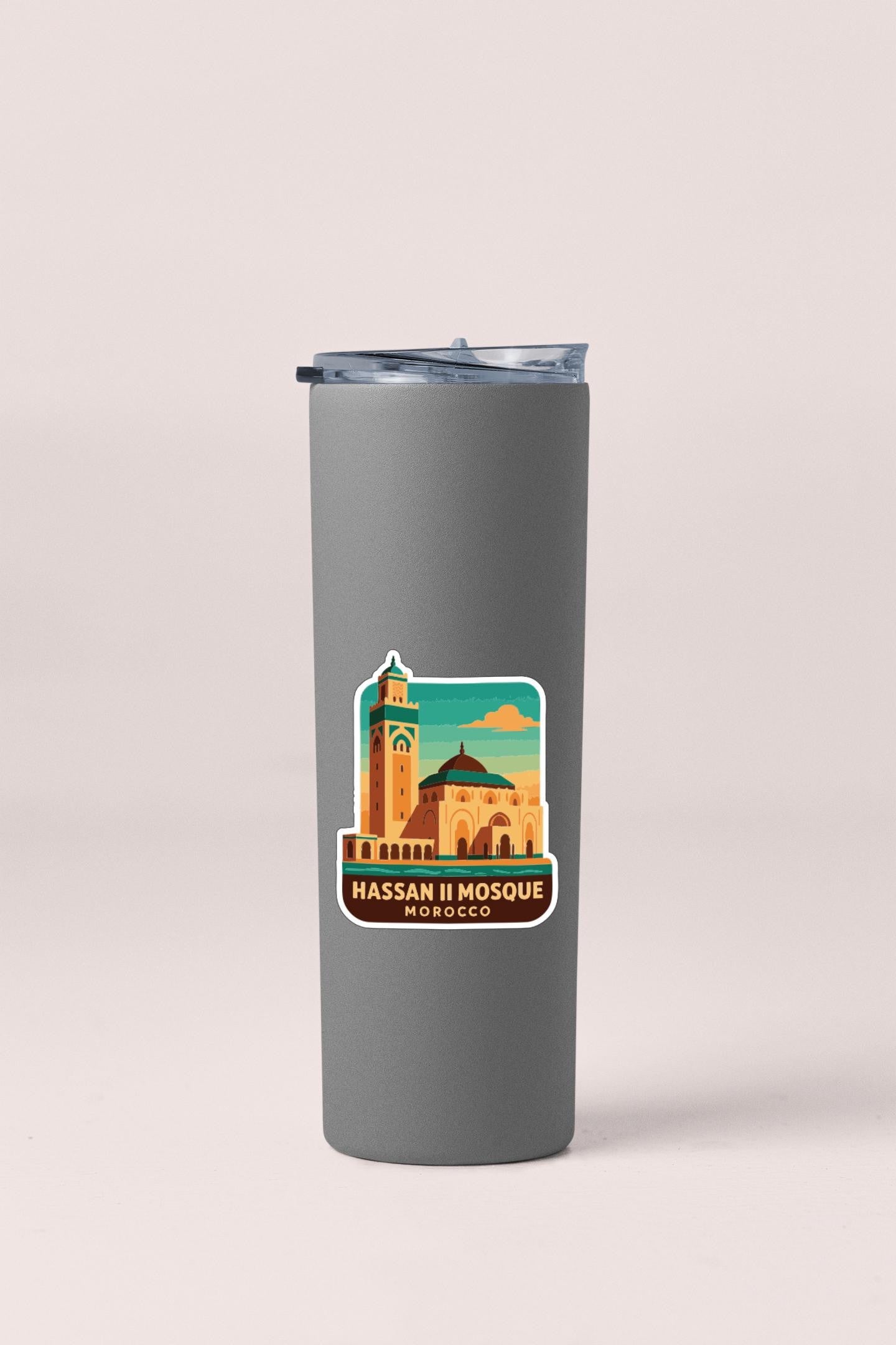 A gray insulated tumbler with a sticker depicting the Hassan II Mosque in Morocco.