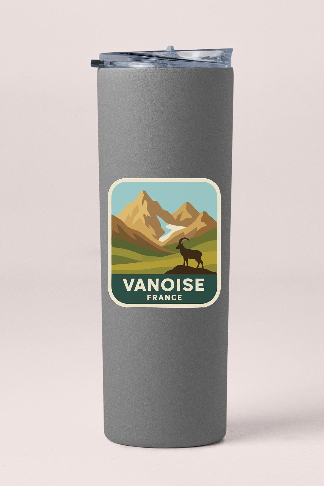 A gray cylindrical container with a label that features a mountain landscape and a silhouette of a mountain goat.