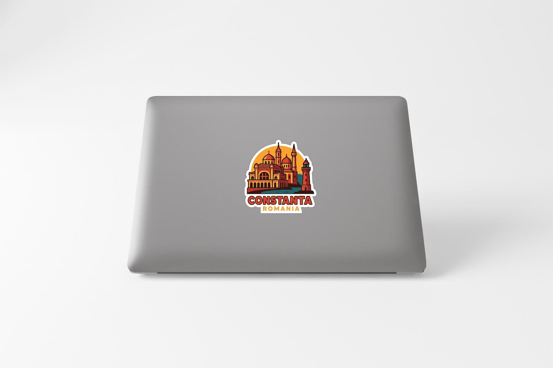 a sticker with a graphic of a building and the text "CONSTANTA ROMANIA" on a grey laptop.
