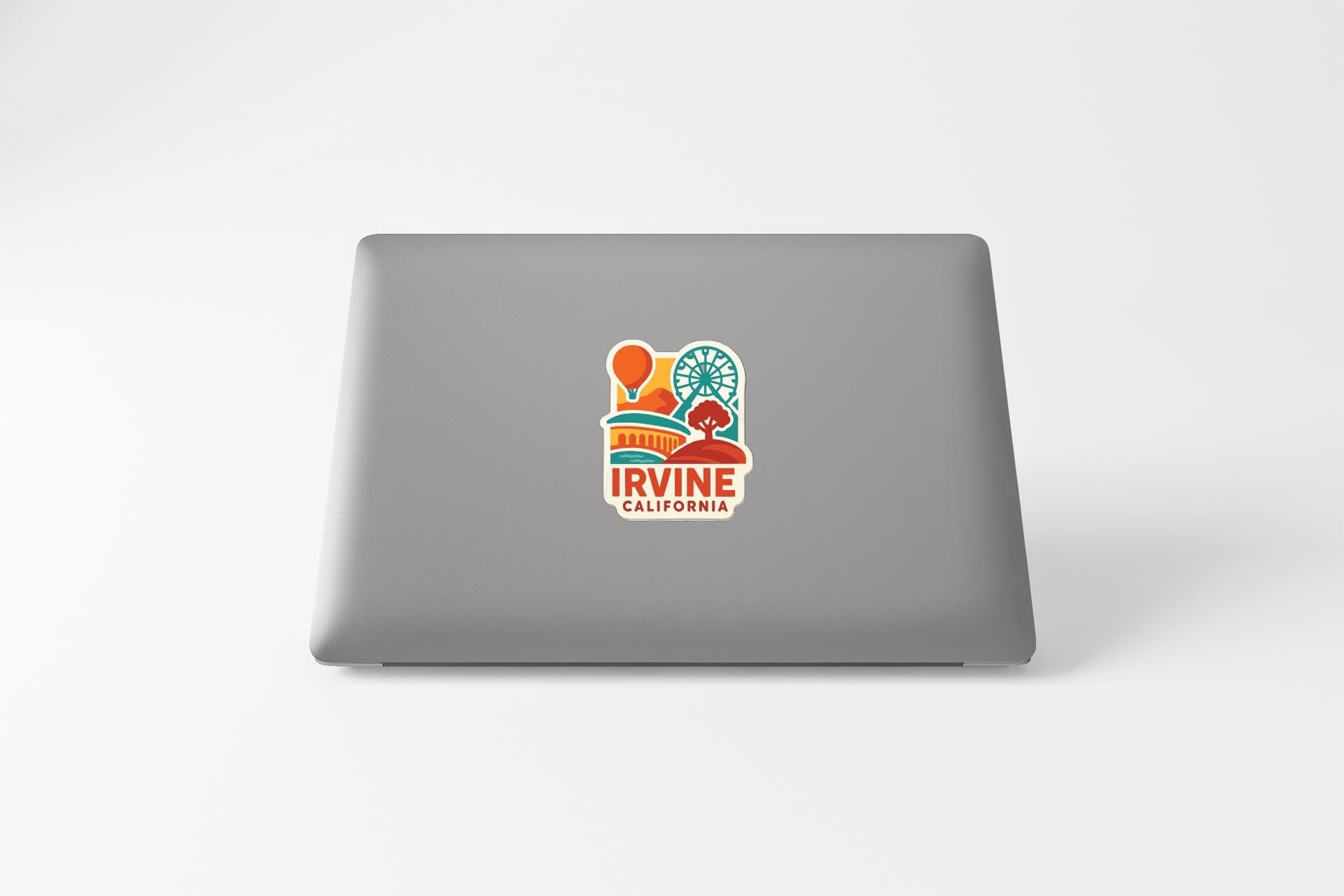 a sticker with a graphic of a cityscape and the text "IRVINE CALIFORNIA" on the back of a laptop.
