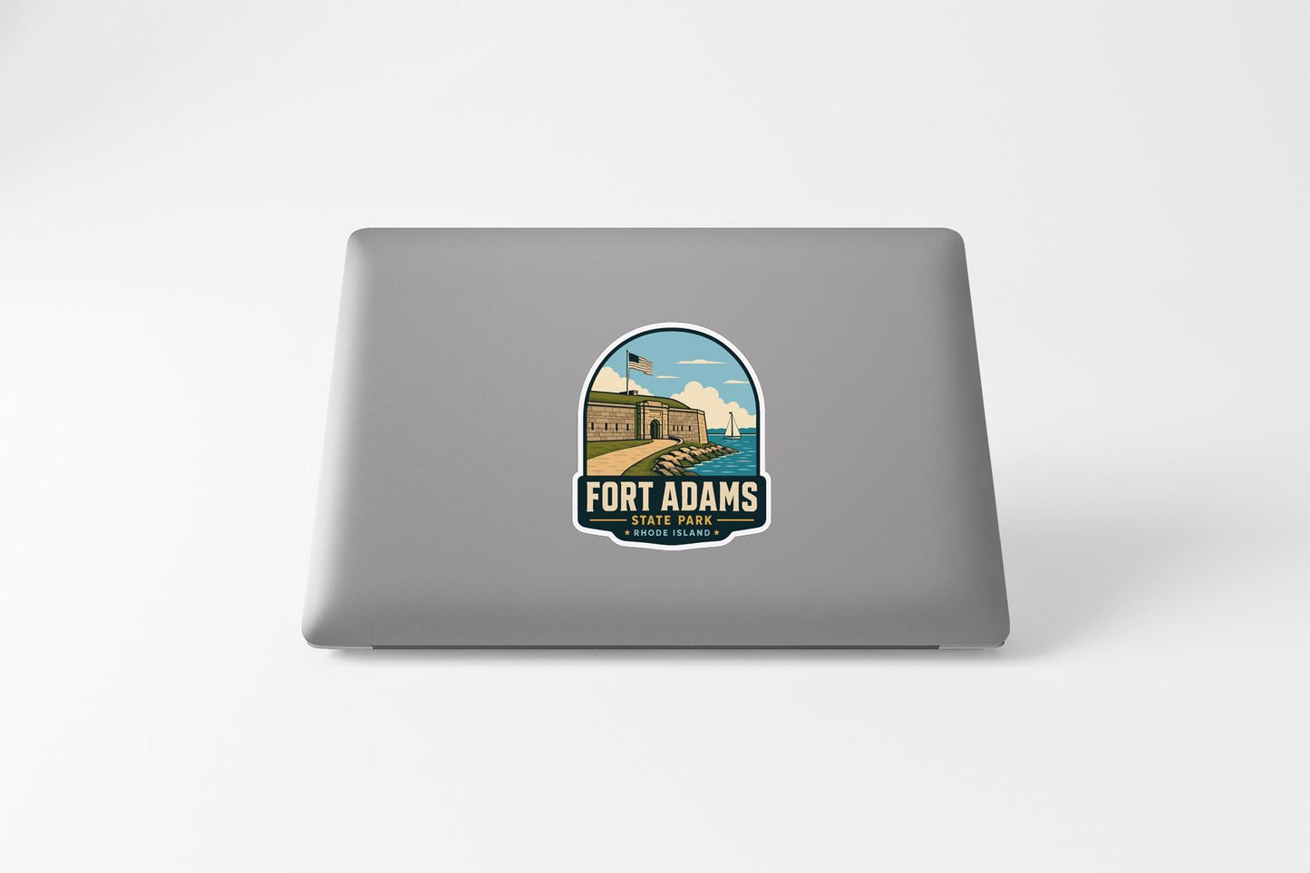 a sticker on the back of a laptop that displays the name 'FORT ADAMS' and a graphic of a building, likely representing Fort Adams.
