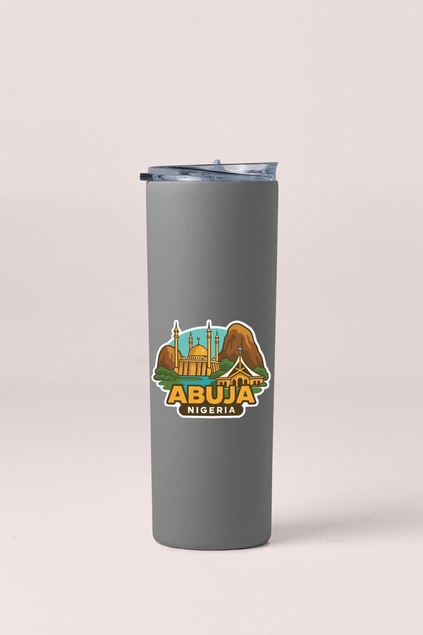 A gray tumbler with a sticker depicting the skyline of Abuja, Nigeria.
