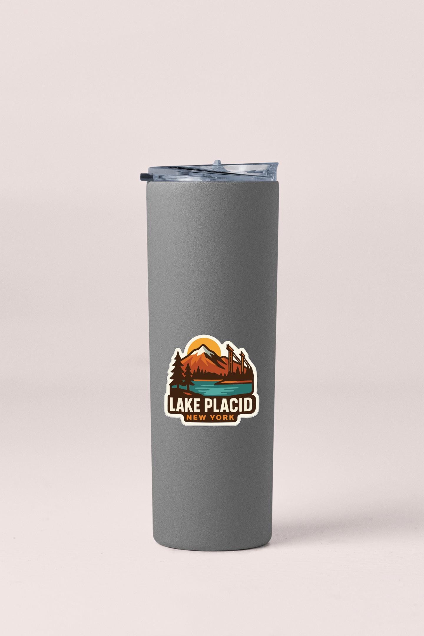 A gray insulated tumbler with a logo on it.