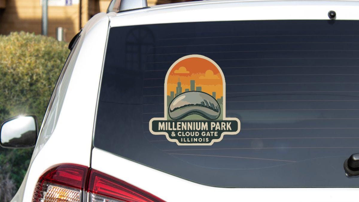 the rear window of a white car with a sticker on it. The sticker features an illustration of a city skyline and the text "Millennium Park & Cloud Gate Illinois".