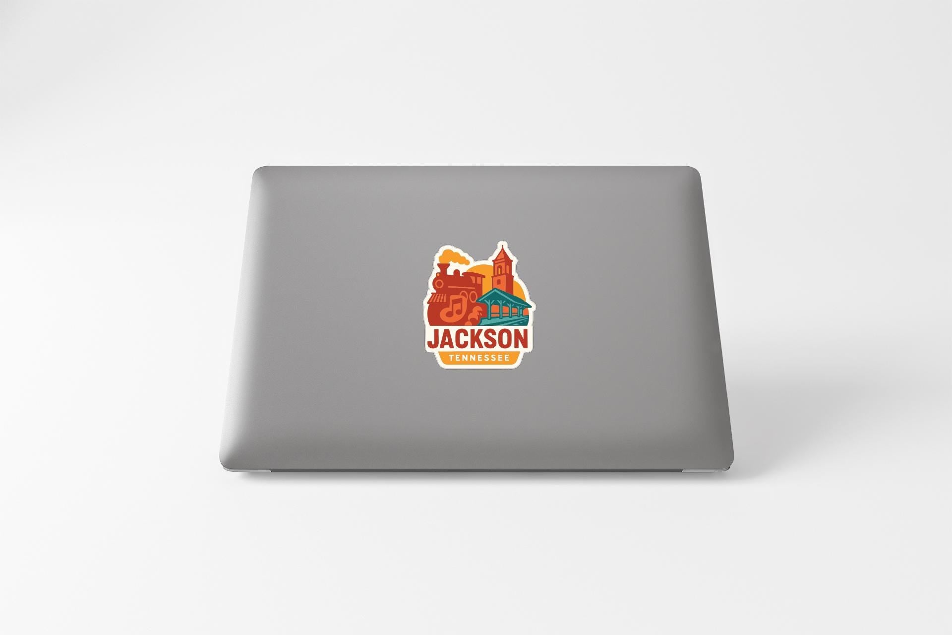 A sticker on the back of a laptop displaying the text "JACKSON TENNESSEE" along with an illustration of a cityscape.
