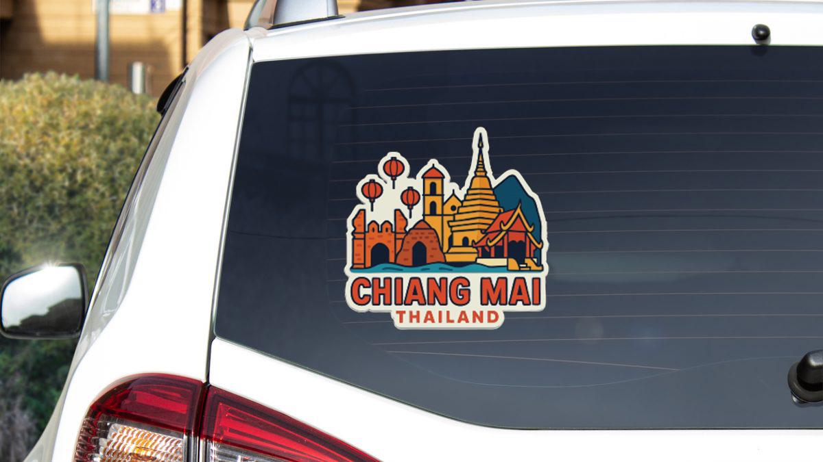 A sticker on the rear window of a car, depicting the skyline of Chiang Mai, Thailand.