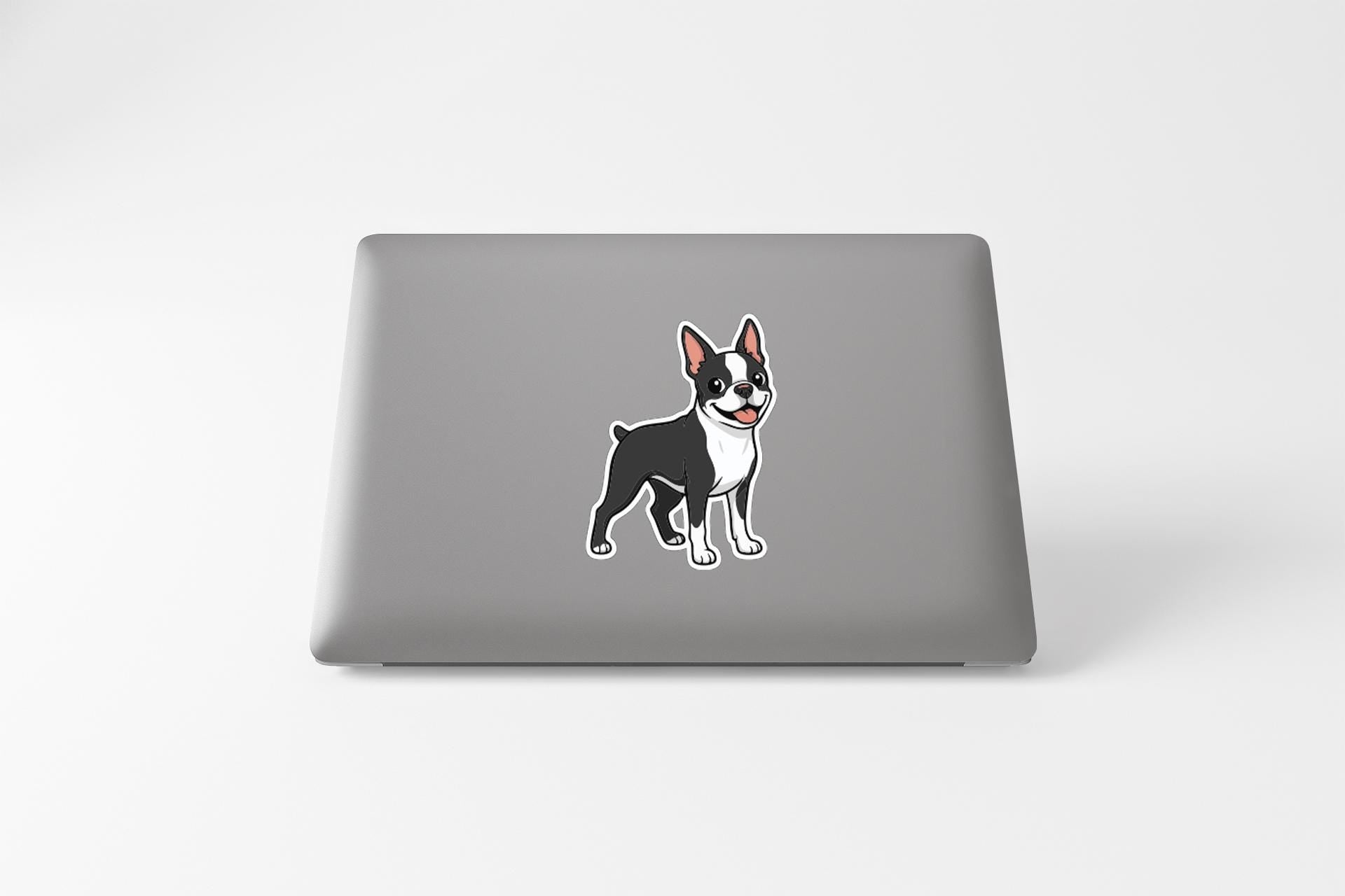 A sticker of a cartoon dog is on the back of a laptop.
