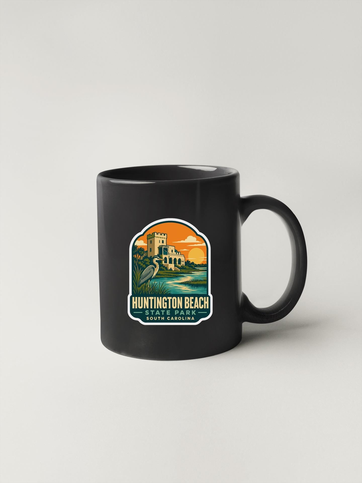 A black coffee mug with a label that says "HUNTINGTON BEACH" and "SOUTH CAROLINA" printed on it.