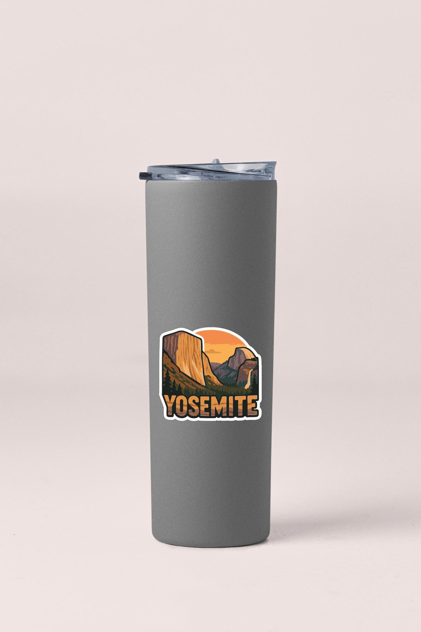 A gray insulated tumbler with a sticker depicting the scenic landscape of Yosemite National Park.