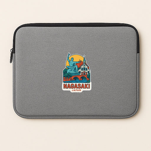 A gray laptop sleeve with a colorful sticker depicting a statue and buildings, along with the text "Nagasaki Japan".