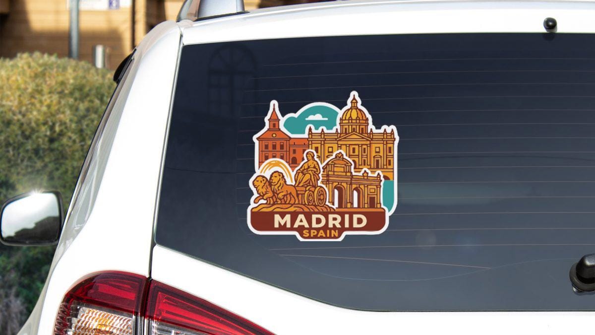 A sticker on the rear window of a car, depicting the city of Madrid, Spain.