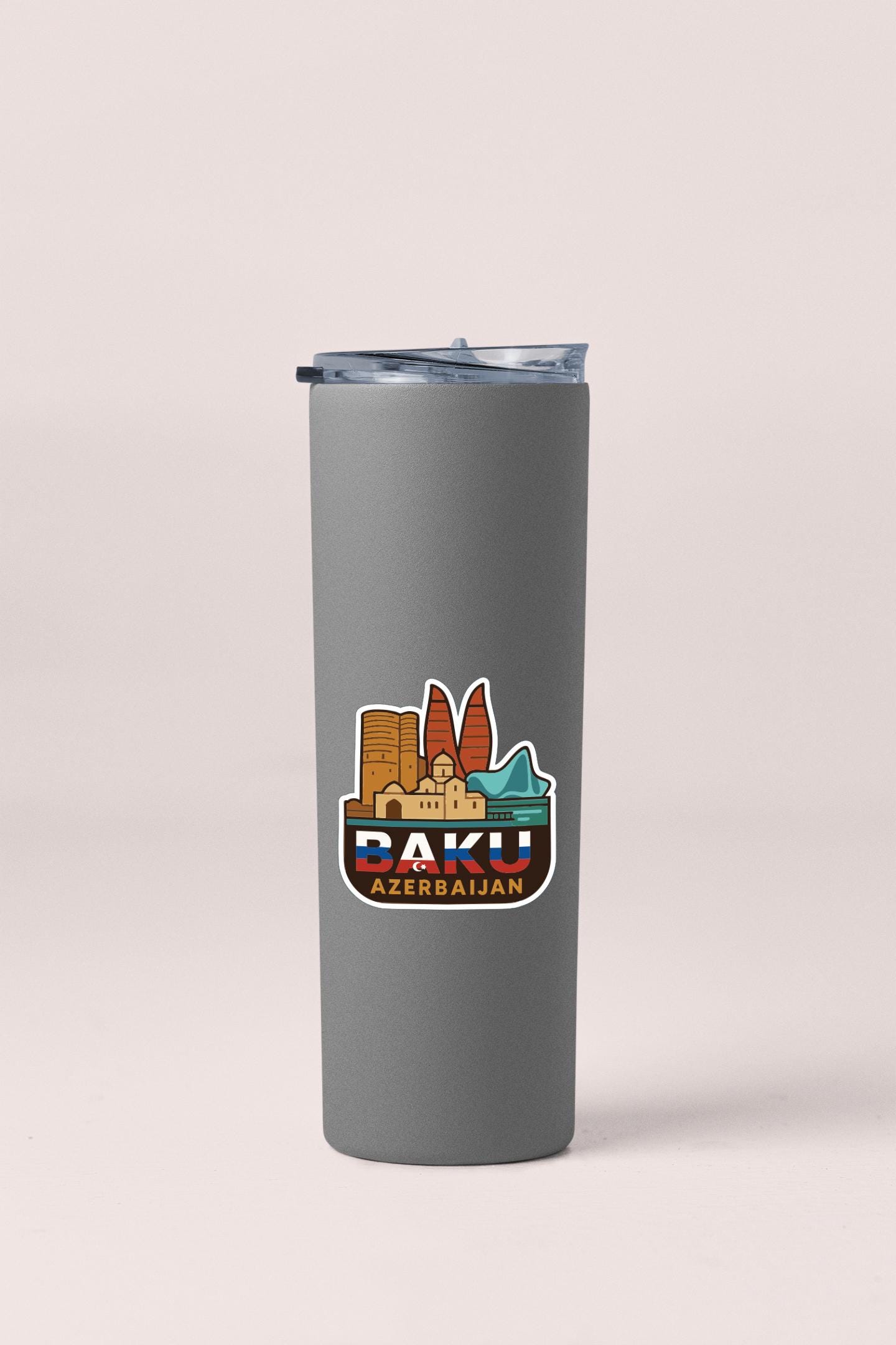 A gray insulated tumbler with a sticker depicting the cityscape of Baku, Azerbaijan.
