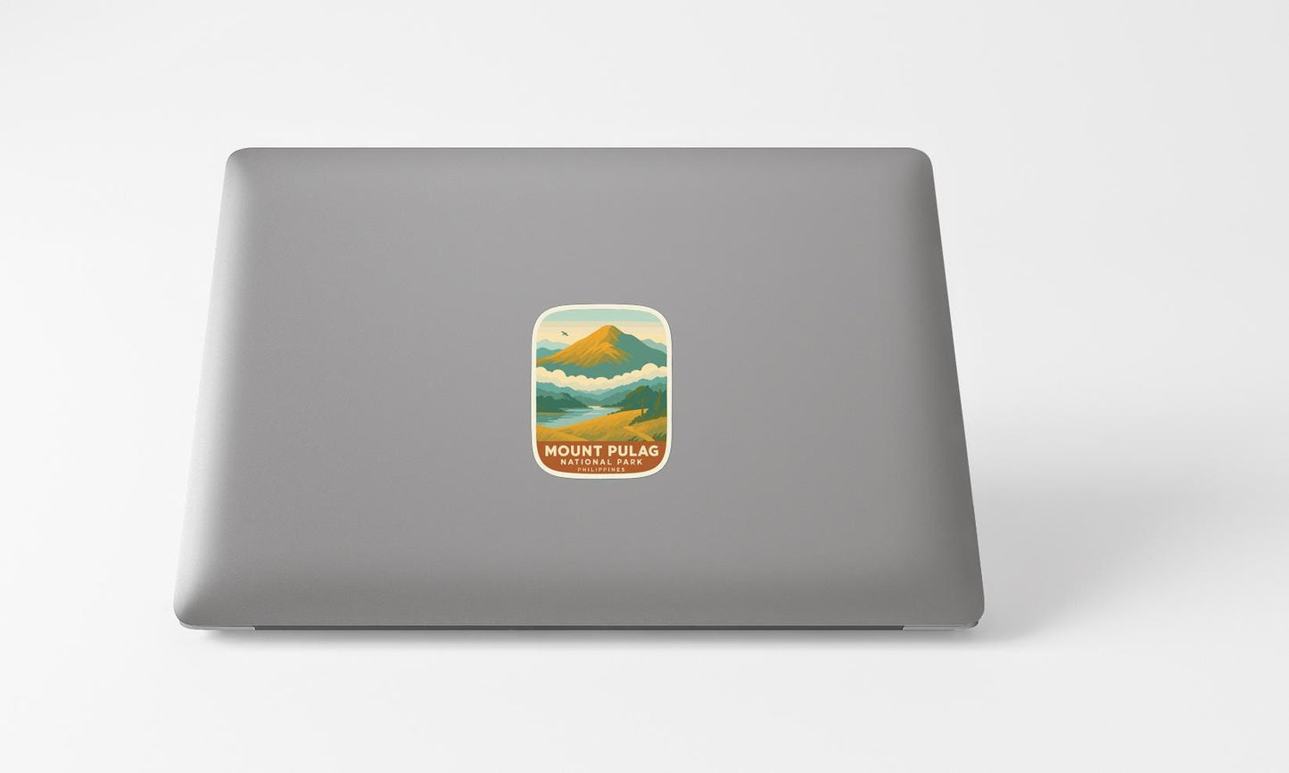 A sticker of a mountain landscape on the back of a laptop computer.