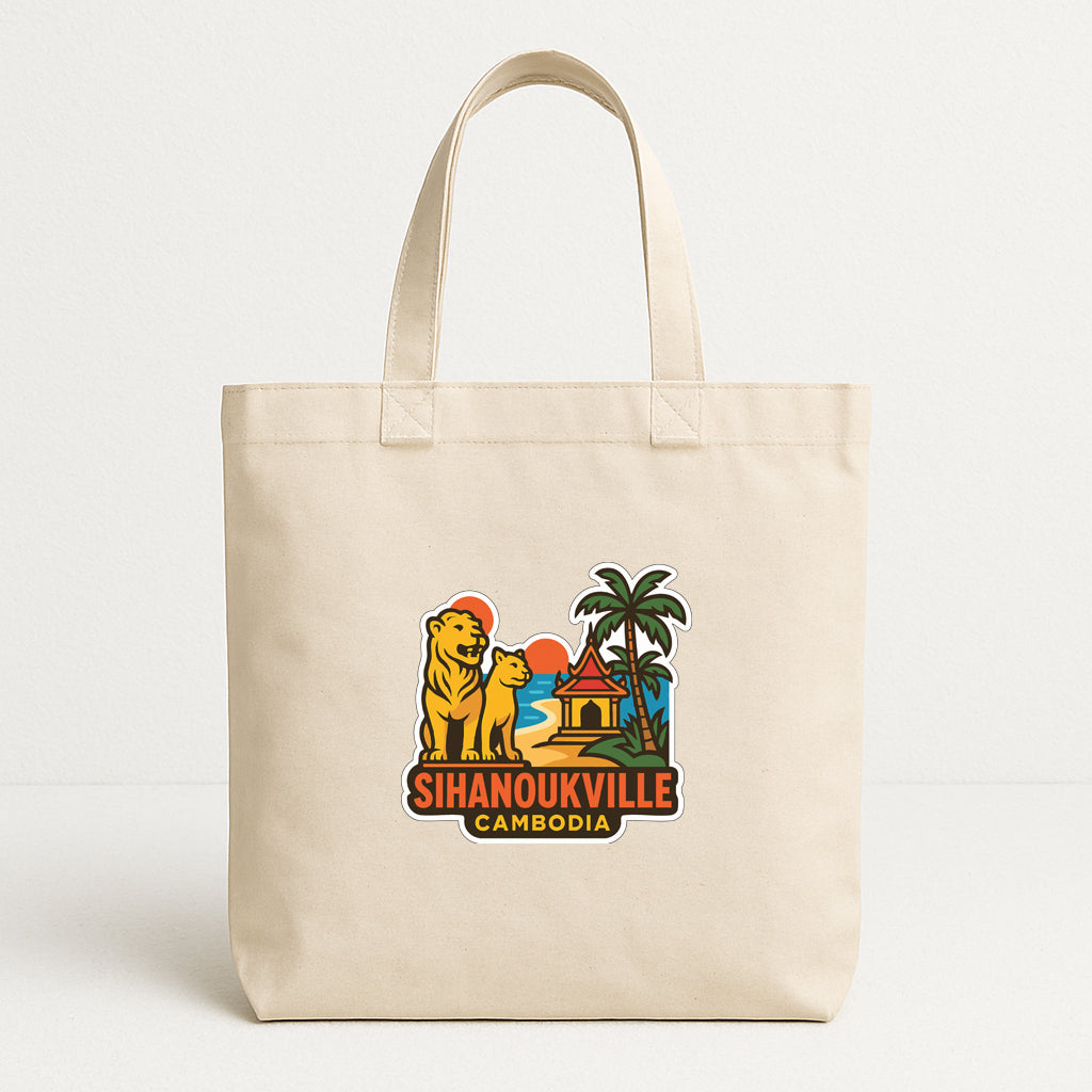 A beige tote bag with a colorful graphic depicting a tropical scene, including a lion, palm tree, and a building, along with the text "Sihanoukville Cambodia".