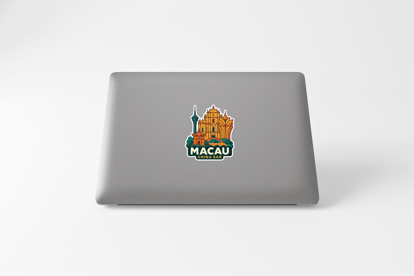 a sticker with an illustration of a building and the text "MACAU" on a laptop.