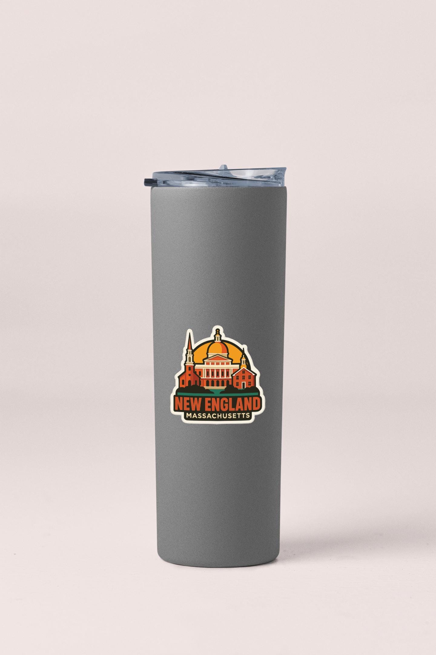 A gray insulated tumbler with a lid and a sticker depicting the New England state of Massachusetts.