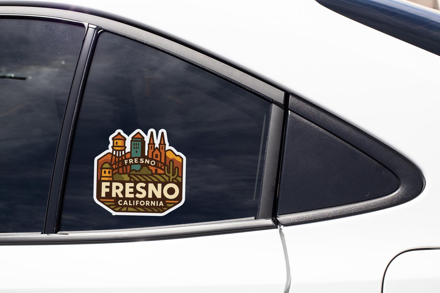 A sticker on the side of a car window, featuring an illustration of a cityscape with the text "FRESNO CALIFORNIA".