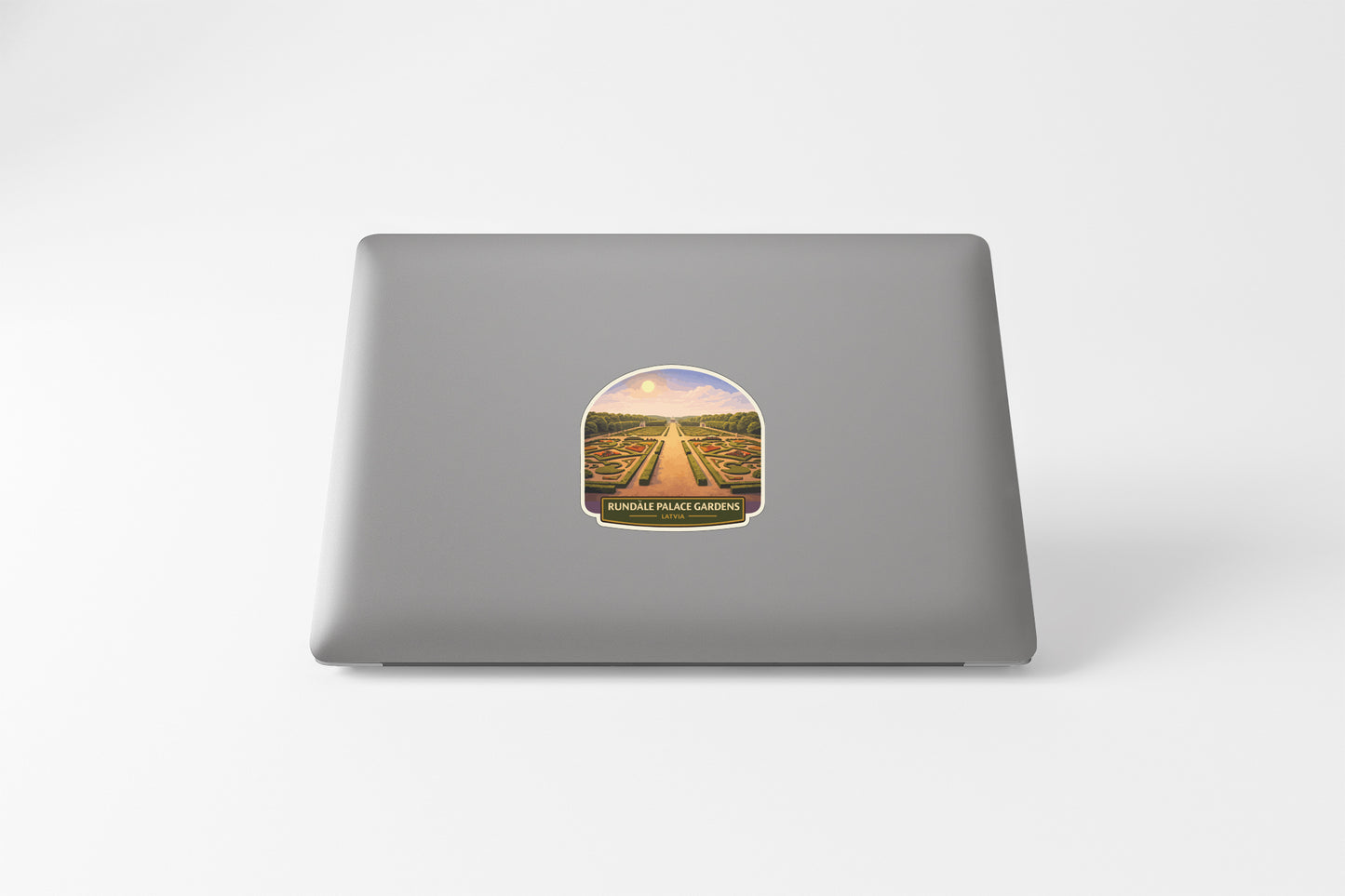 a sticker on a laptop with a scenic landscape of a road leading through a field of flowers.