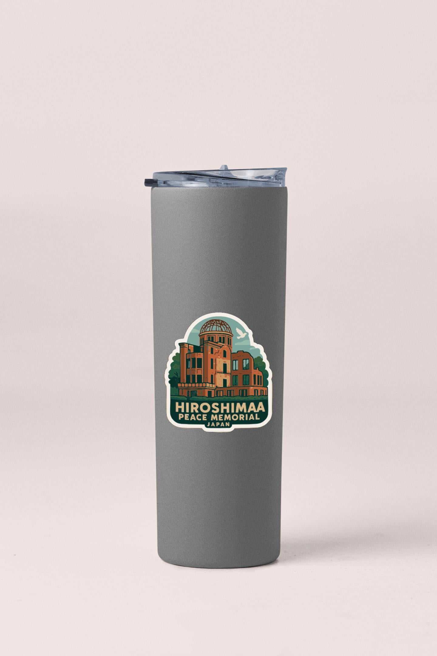 A gray insulated tumbler with a sticker depicting the Hiroshima Peace Memorial in Japan.