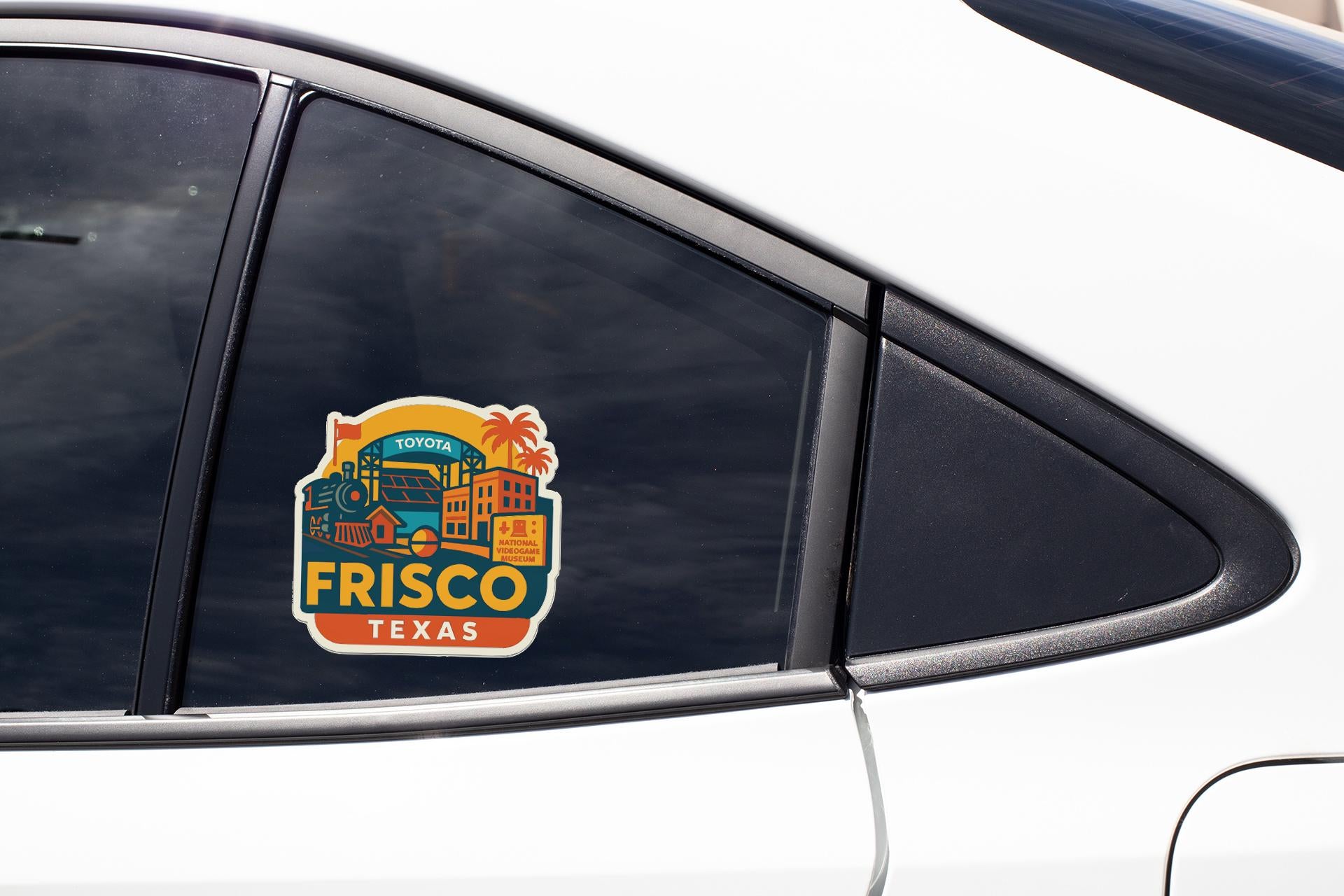 A sticker on the side of a car window, featuring a colorful illustration of a cityscape with the text "FRISCO TEXAS".