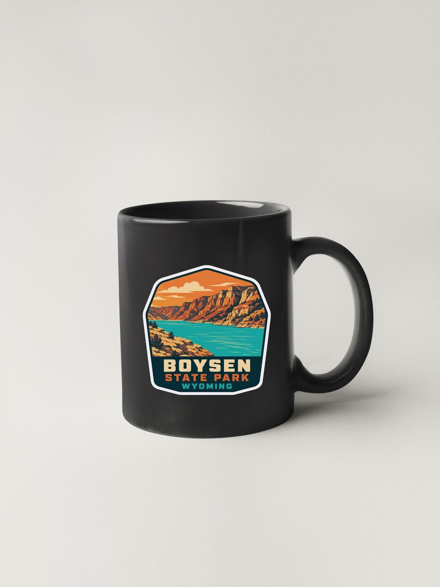 A black coffee mug with a graphic design depicting Boysen State Park in Wyoming.