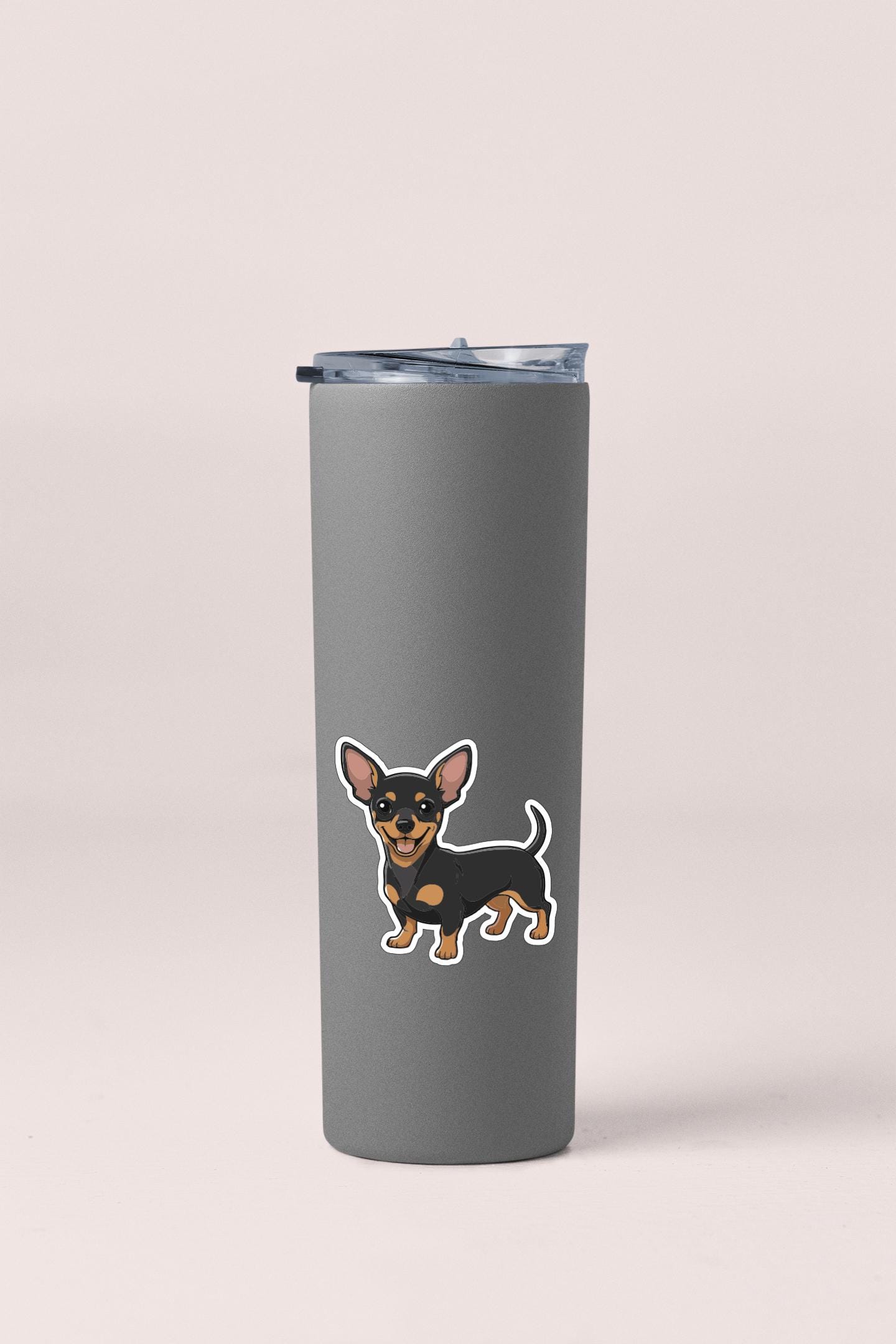 A gray insulated tumbler with a sticker of a small dog on it.