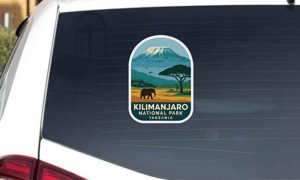 A sticker on the rear window of a car that says "KILIMANJARO NATIONAL PARK TANZANIA".