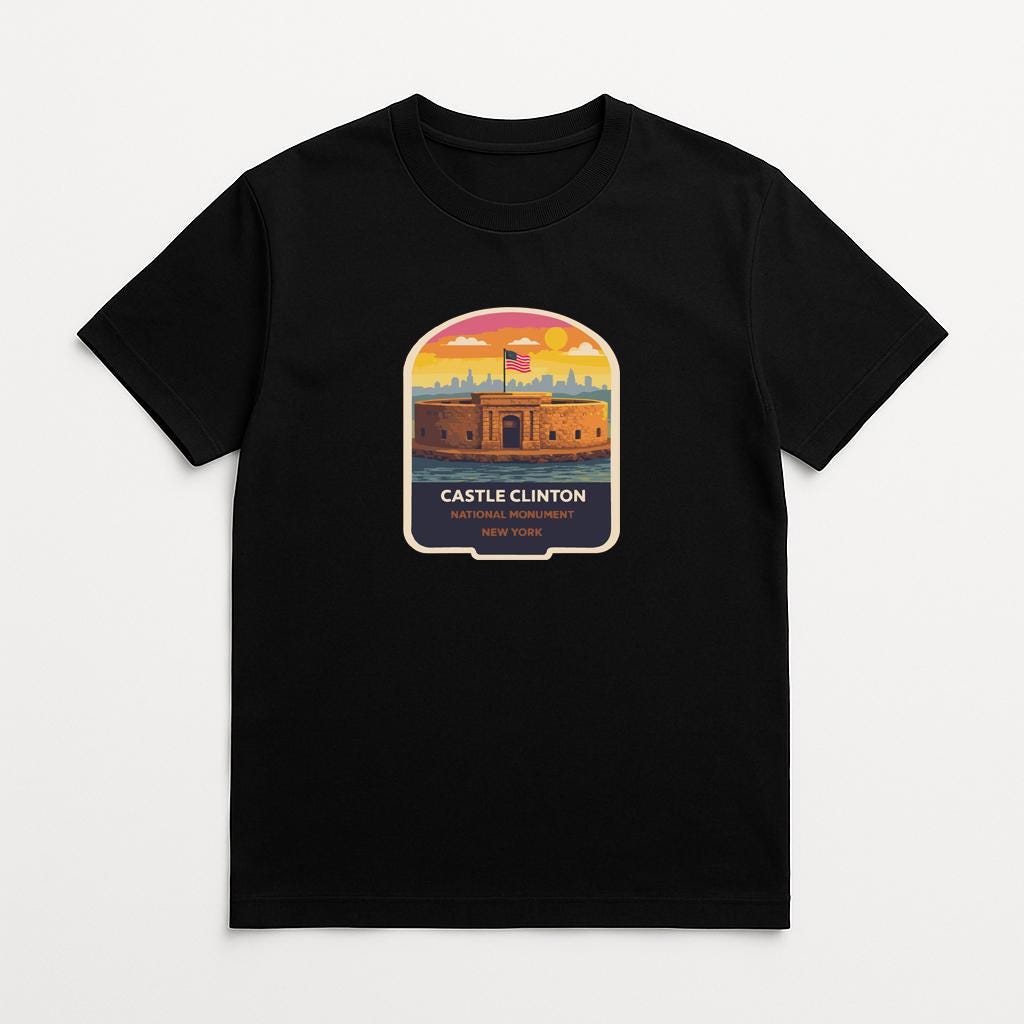 A black t-shirt with a graphic design depicting a castle or fortification, along with the text "CASTLE CLINTON NEW YORK".
