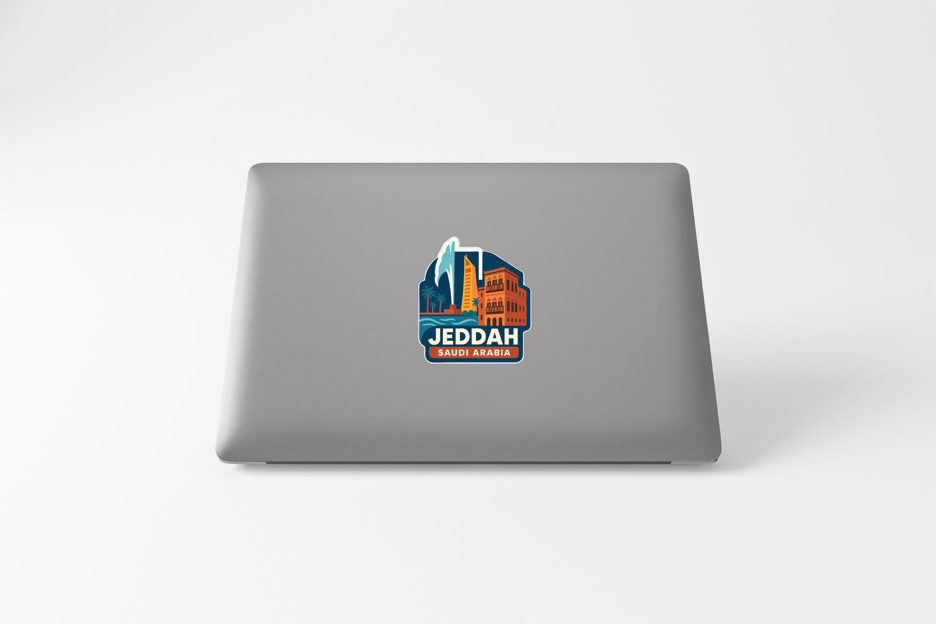 a laptop with a sticker on the back cover that says "JEDDAH SAUDIA ARBAH".