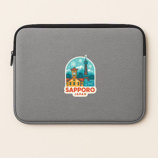 A gray laptop sleeve with a colorful sticker depicting the Sapporo, Japan, skyline.