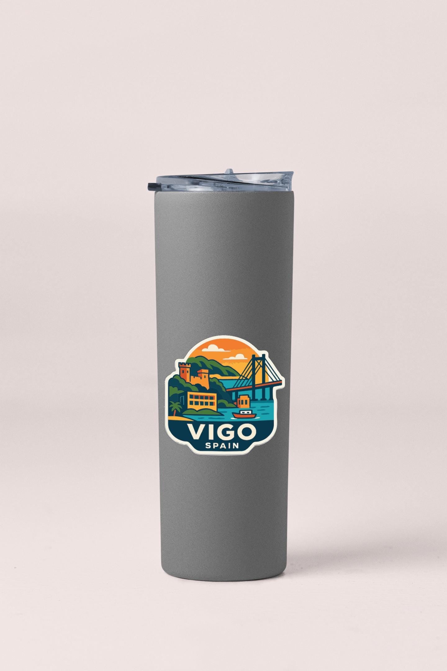 A gray insulated tumbler with a sticker depicting a scenic view of Vigo, Spain.