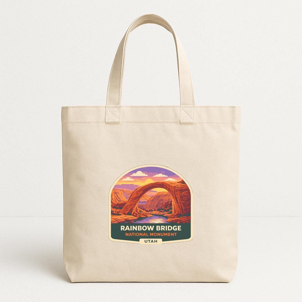 A beige tote bag with a graphic design depicting the Rainbow Bridge in Utah.