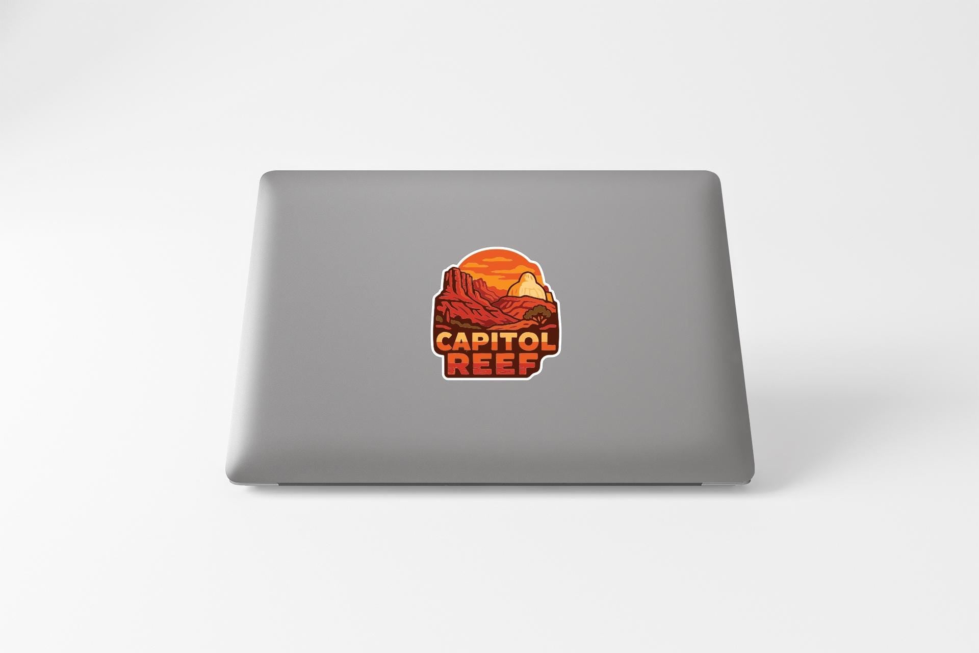 a sticker with the text "CAPITOL REEF" on the back of a laptop.