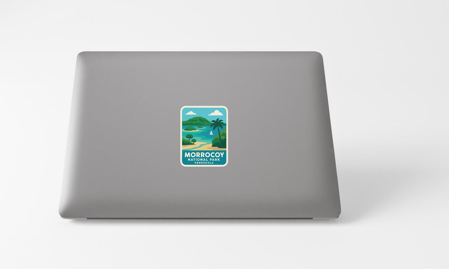 A sticker on the back of a laptop displaying a tropical beach scene with palm trees and a body of water.