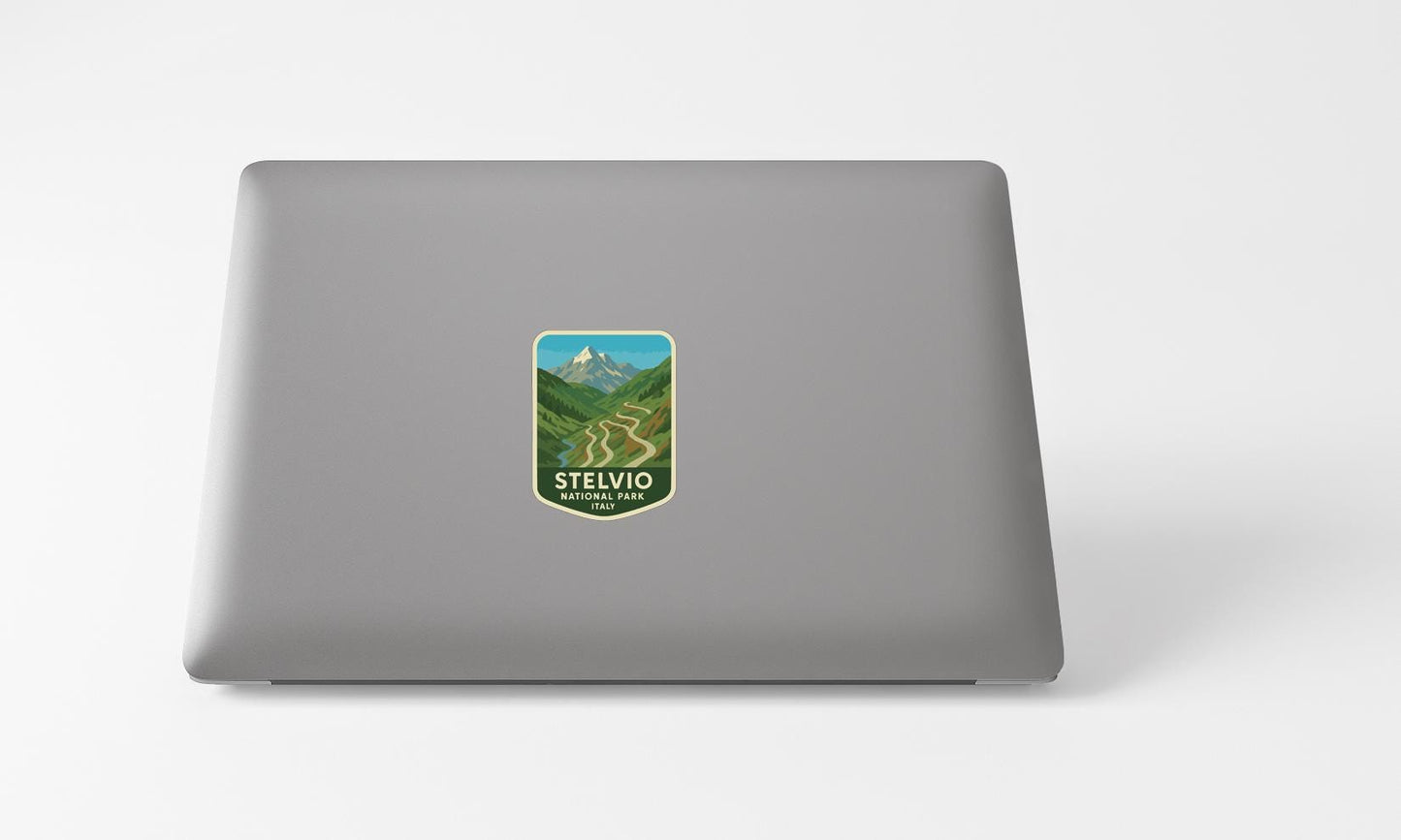 A sticker with a mountain landscape and the text "STELVIO NACIONAL ITALY" is placed on the back of a laptop computer.
