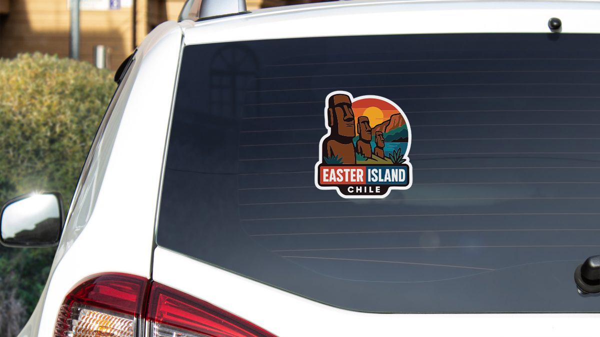 A sticker on the rear window of a white car, depicting Easter Island and Chile.