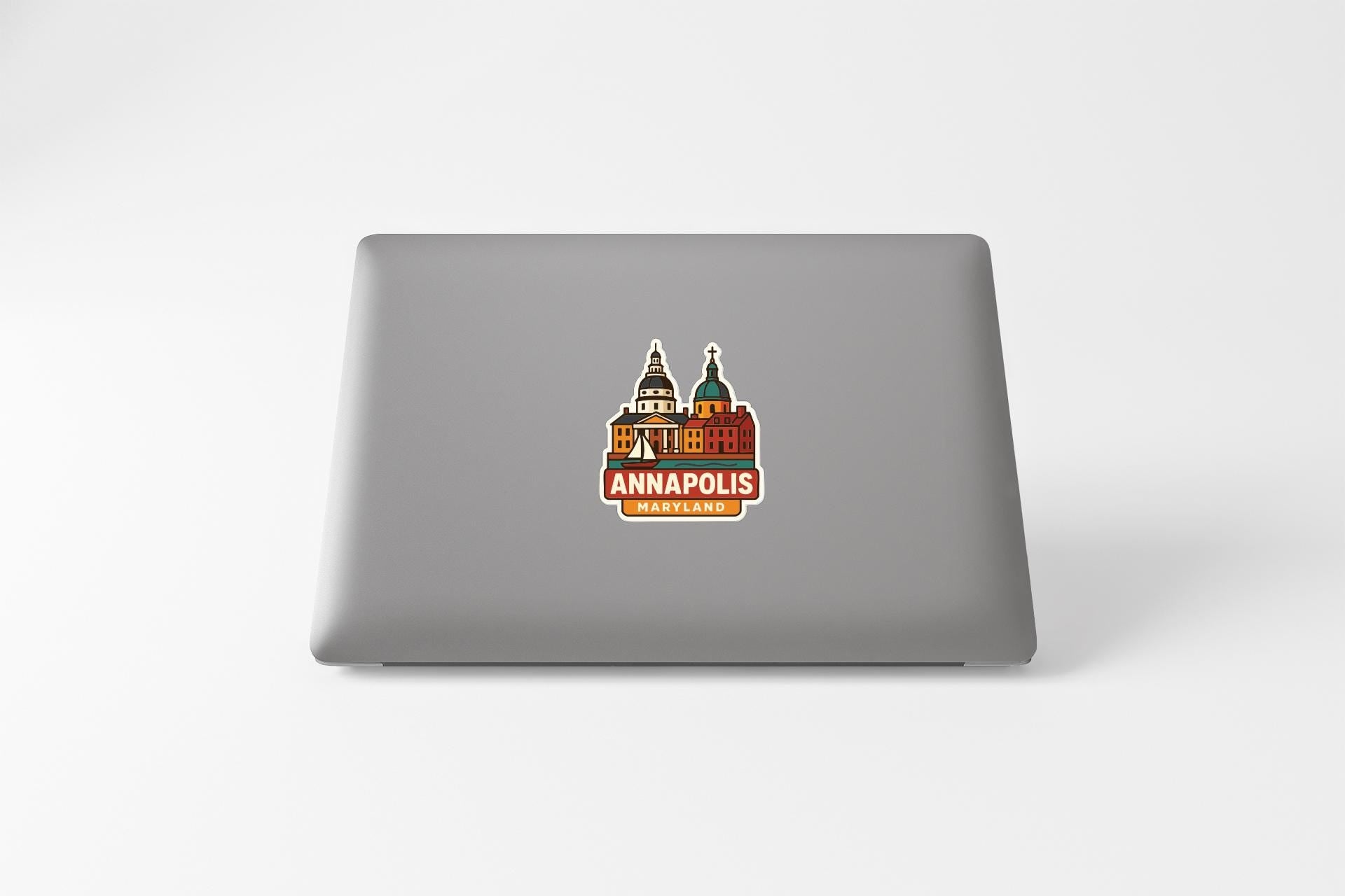 a sticker with a graphic of a building and the text "ANNAPOLIS, MD" on the back of a laptop.