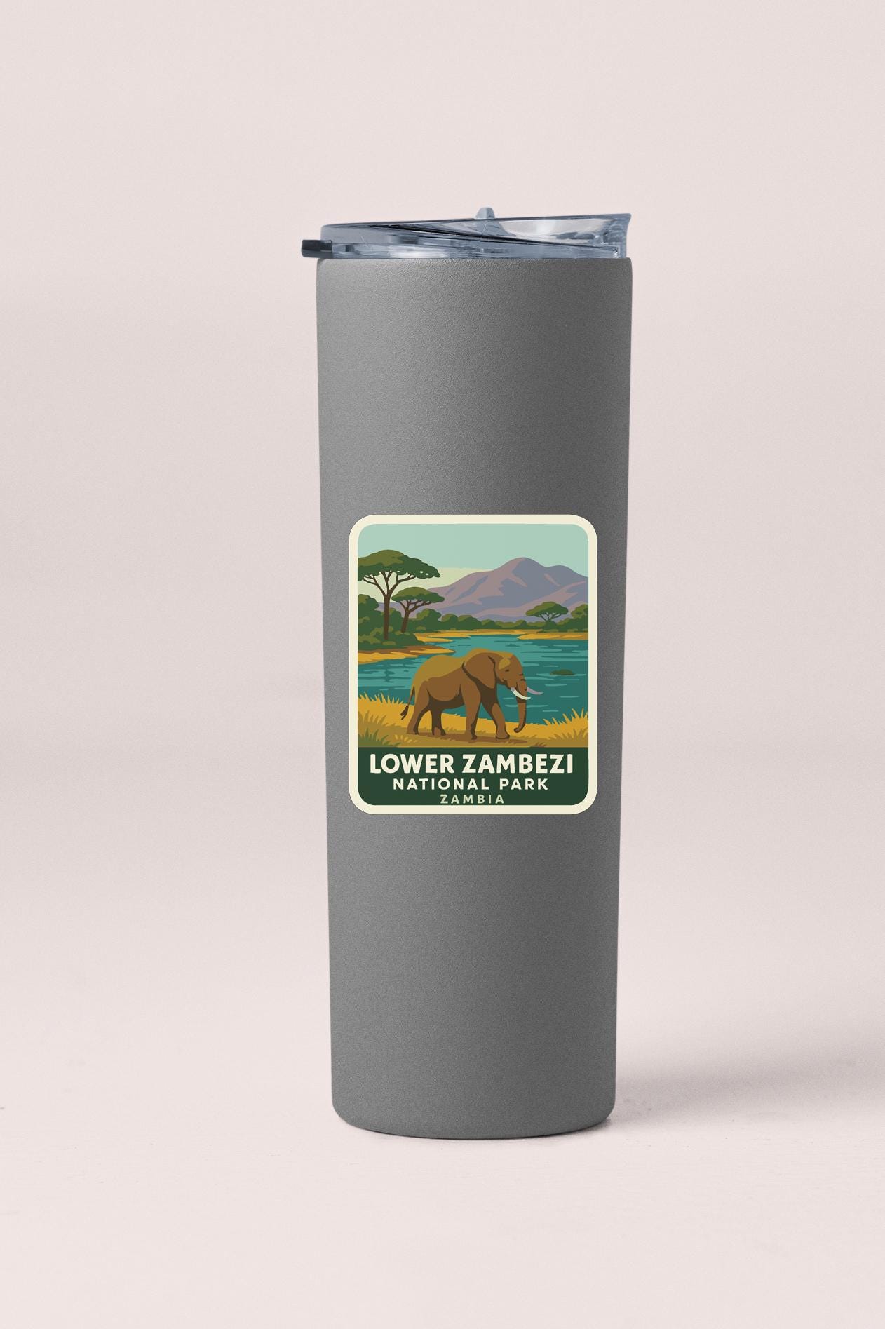 A gray tumbler with a label that features an illustration of an elephant in a grassy field near a body of water, along with the text "Lower Zambesi National Park".