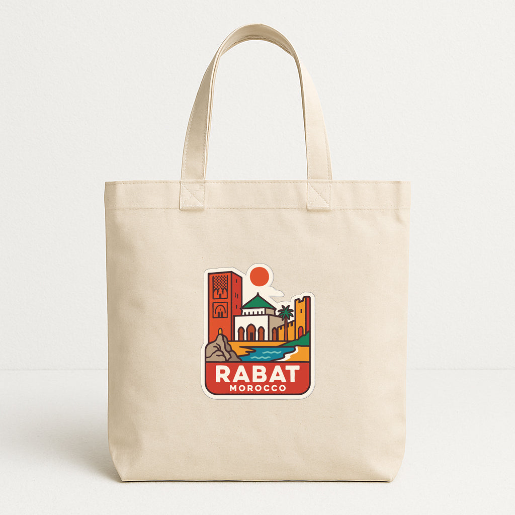 A beige tote bag with a printed design depicting a cityscape and the text "RABAT MOROCCO" printed on it.