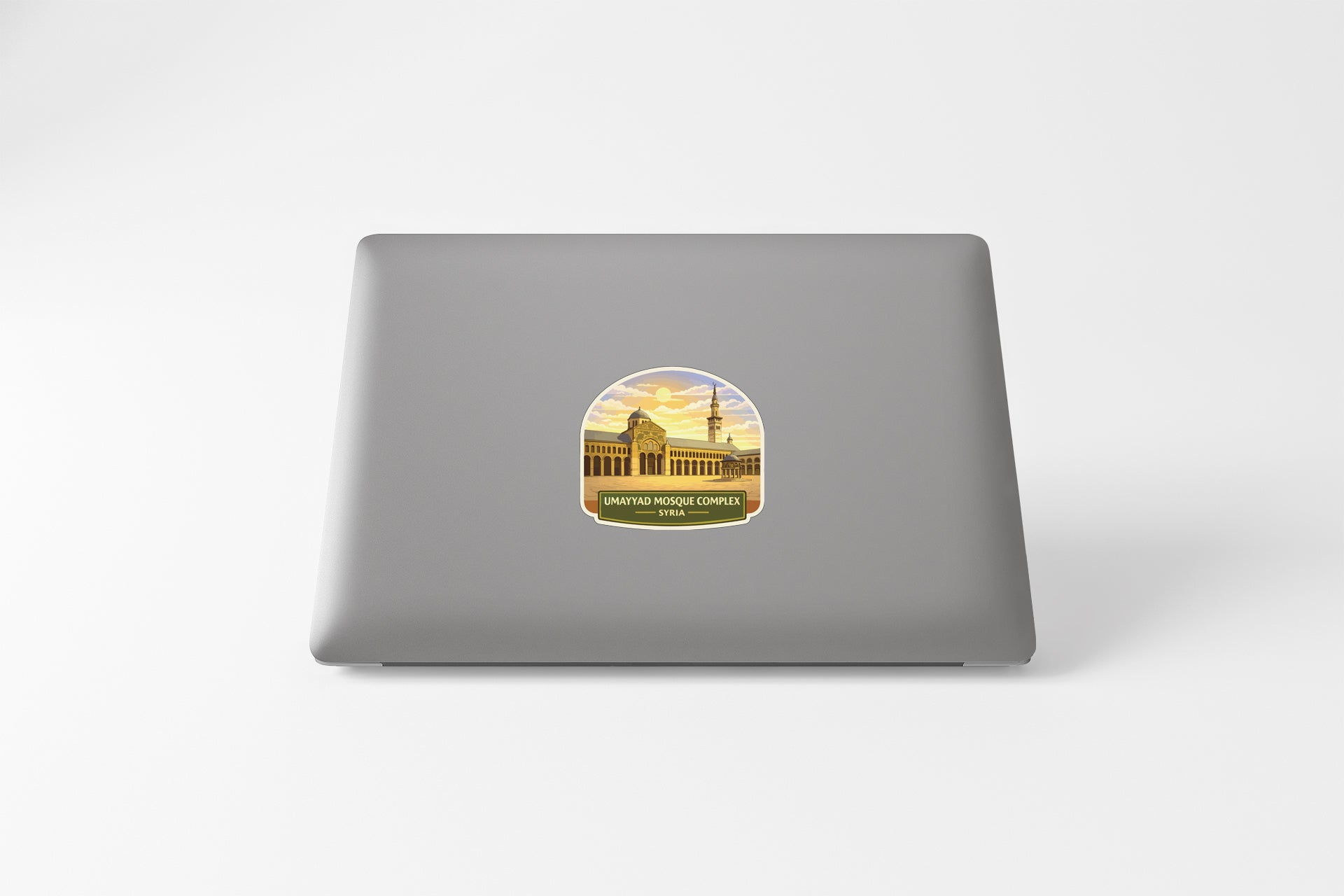 a sticker on the back of a laptop, depicting a building with a tower.
