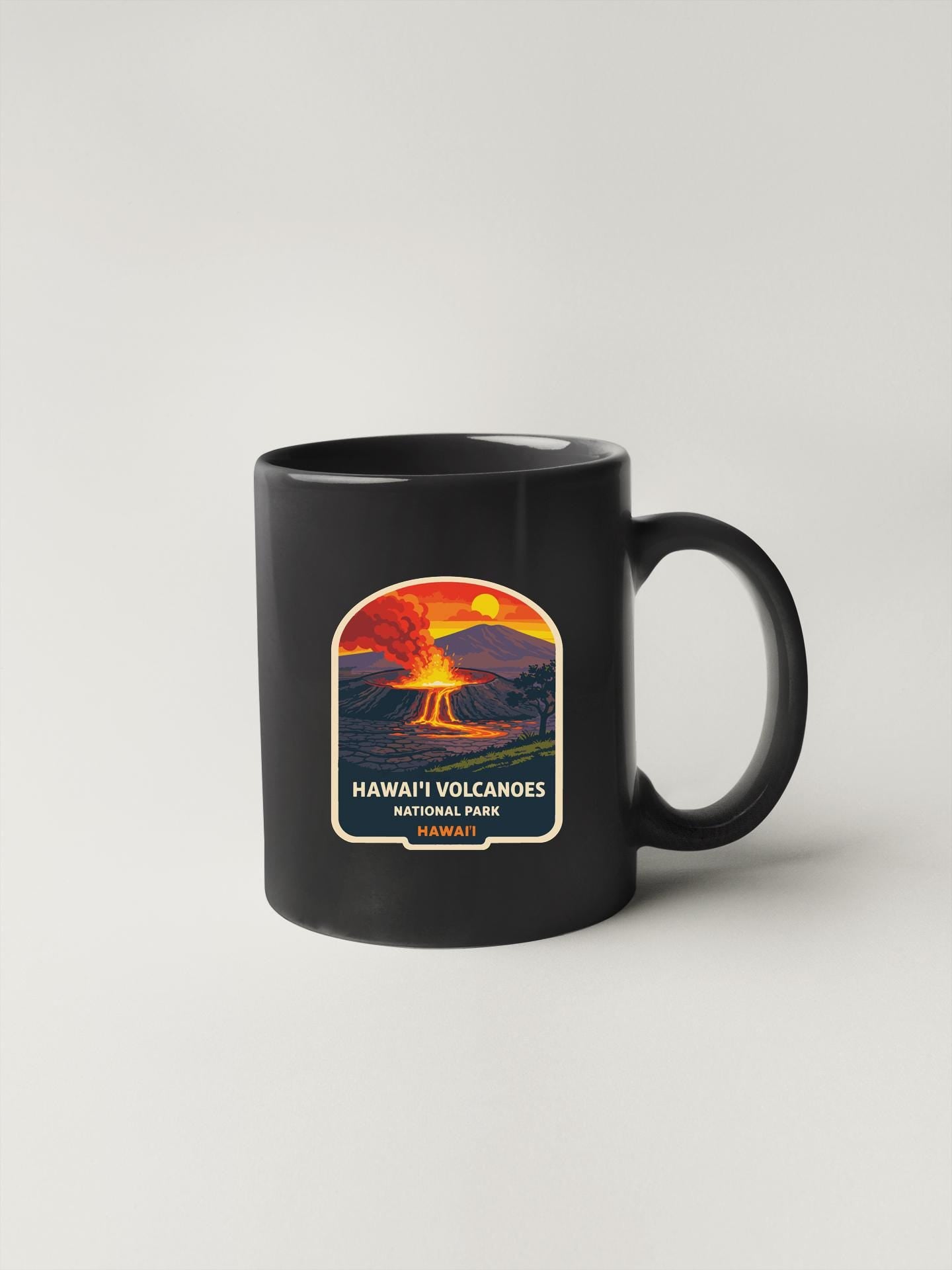 A black coffee mug with a graphic design depicting a volcano and the text "HAWAII' VOLCANOES NATIONAL PARK" printed on it.
